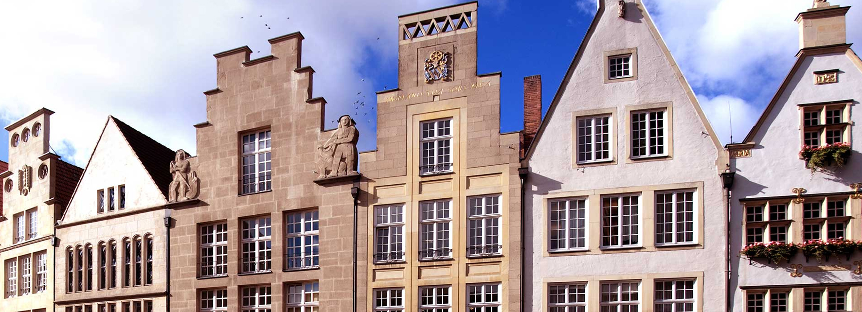 Historische Giebelhäuser am Prinzipalmarkt in Münster unter blauem Himmel