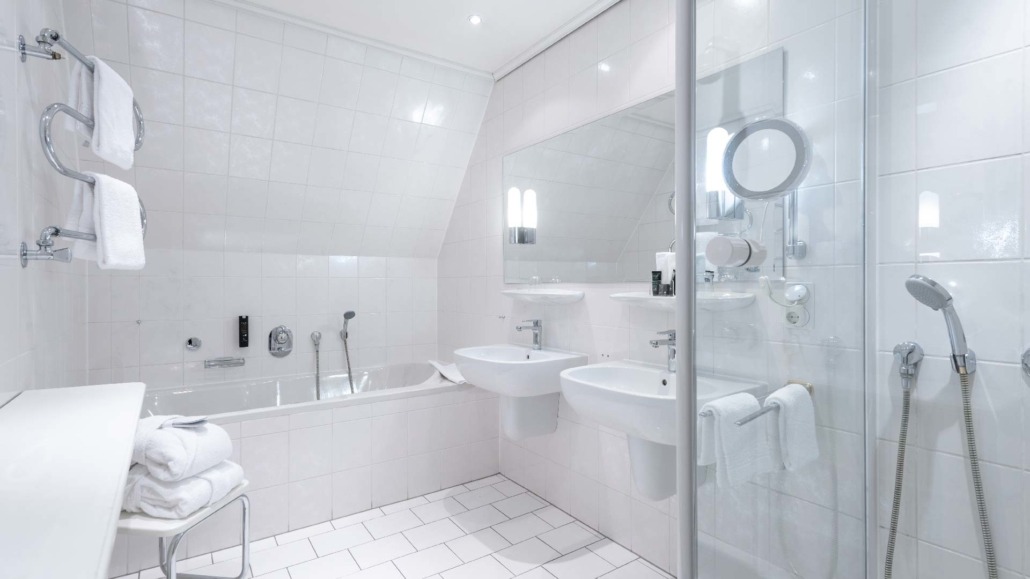 Suite Badezimmer Moderne Suite-Badezimmer mit Badewanne, zwei Waschbecken, begehbarer Dusche und weißen Fliesen